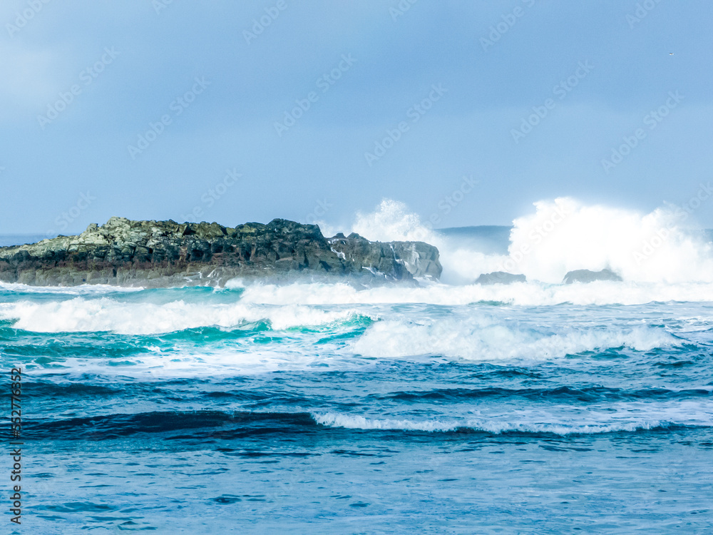 Strong waves hitting the rocks in a turquoise blue sea Strong waves hitting the rocks in a turquoise blue sea