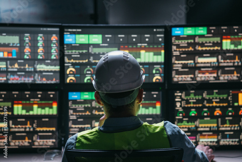 Main engineer following the plant process using Industry 4.0. Operator control process of production uses computer screens with SCADA system