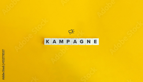 Kampagne (Word Campaign in German Language). Word and Megaphone Icon on Block Letter Tiles on Yellow Background. Minimal Aesthetics.