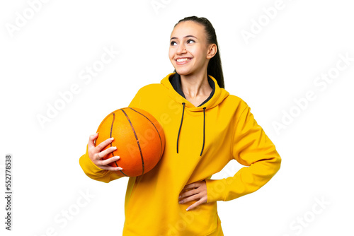 Young Arabian woman playing basketball over isolated wall  over isolated chroma key background posing with arms at hip and smiling © luismolinero