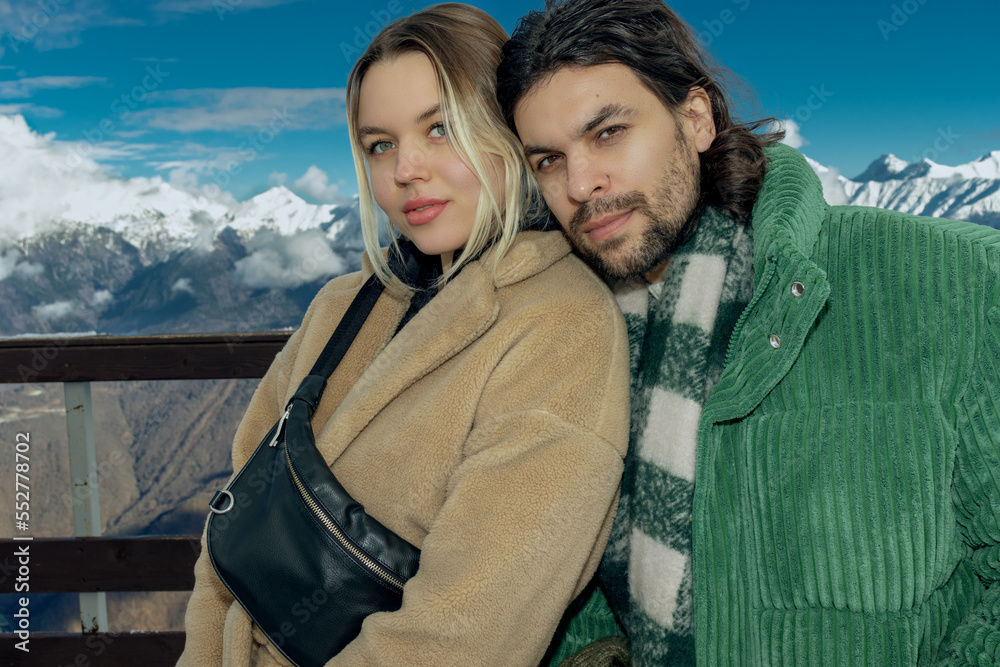 Guy and girl posing on the observation deck in the snowy mountains