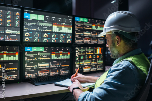 Main engineer following the plant process using Industry 4.0. Operator control process of production uses computer screens with SCADA system