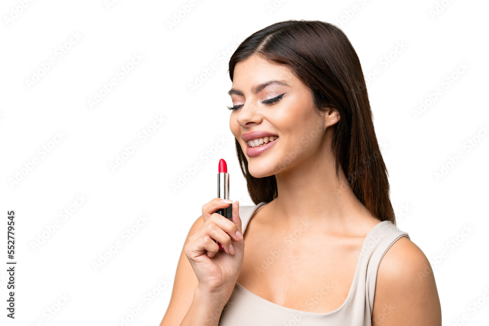 Young Russian woman with rainproof coat and umbrella over isolated chroma key background holding red lipstick Young Russian woman with rainproof coat and umbrella over isolated chroma key background holding red lipstick