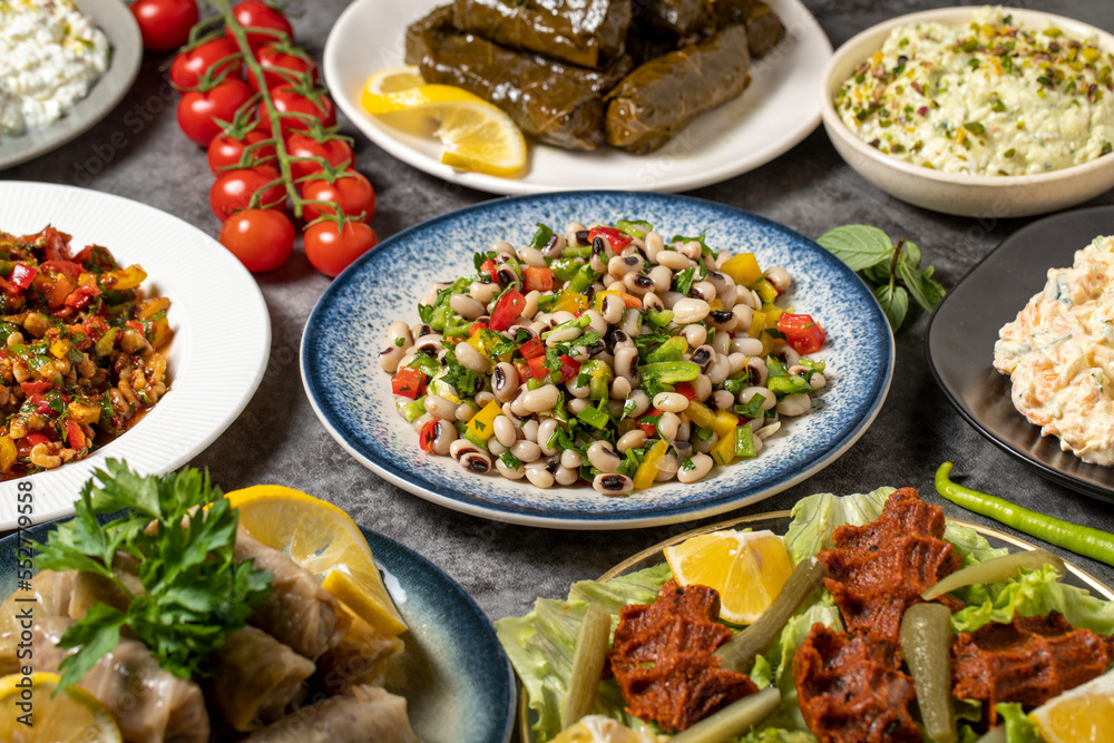 Traditional Turkish and Greek dinner appetizer table. Mediterranean appetizer concept. Dry cowpea salad, roasted eggplant salad, stuffed leaves with olive oil, stuffed dried peppers, cabbage rolls Traditional Turkish and Greek dinner appetizer table. Mediterranean appetizer concept. Dry cowpea salad, roasted eggplant salad, stuffed leaves with olive oil, stuffed dried peppers, cabbage rolls