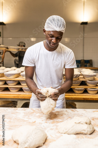 young black man working in a bread factory, learning the trade.