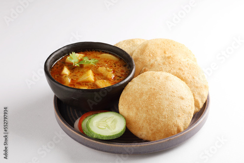 Indian cuisine - Puri Bhaji. It is a traditional breakfast dish in North India. Puri is a deep fried bread made from whole wheat flour and Served with spicy Potato curry called bhaji alu ki sabji. photo