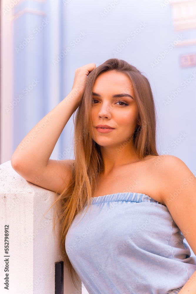 Portrait of attractive young blonde woman in blue dungarees smiling in a blue house Portrait of attractive young blonde woman in blue dungarees smiling in a blue house