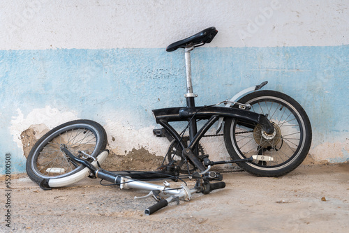 Bicycle with a frame broken in half stands against the wall