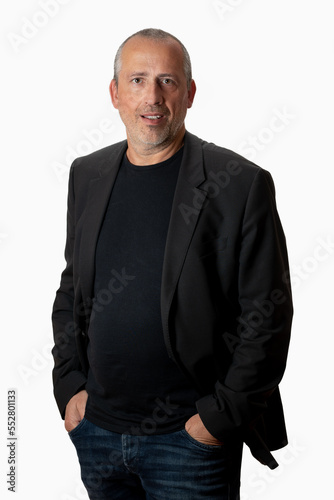 portrait of a handsome middle-aged man looking straight in the camera, waist down, hands in the pockets.