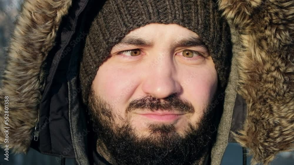 A handsome man looks into the camera. Young man is fooling around on camera. He squints his eyes and shows his tongue standing on the street in winter. Close-up of a young man face. FullHD footage A handsome man looks into the camera. Young man is fooling around on camera. He squints his eyes and shows his tongue standing on the street in winter. Close-up of a young man face. FullHD footage