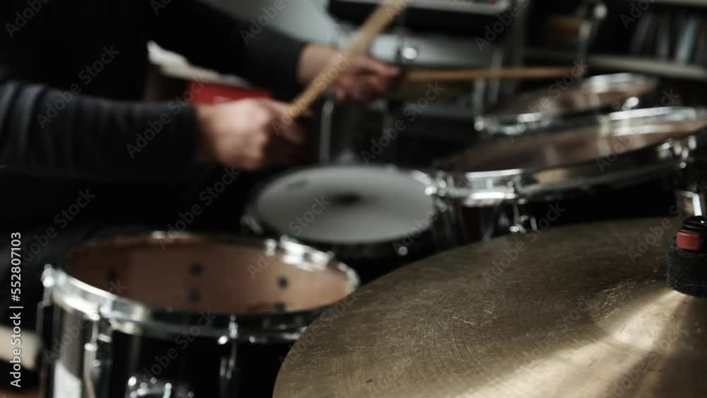 Man hands playing on drums and bronze cymbal plates with drumsticks. Musician during live percussion musical instrument perfomance in recording studio Man hands playing on drums and bronze cymbal plates with drumsticks. Musician during live percussion musical instrument perfomance in recording studio