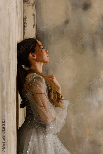 a girl in a dress against a shabby wall