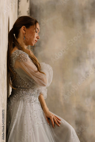 a girl in a dress against a shabby wall