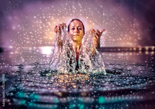 Beautiful woman splashing water in swimming pool. Artist effect.
