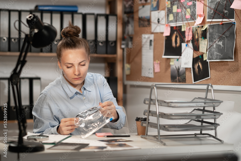 Detective processing evidence in her office at night Detective processing evidence in her office at night