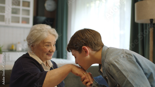 A child kissing his grandmother's hand during the feast (Ramadan or Şeker Bayram). People who adhere to Muslim traditions. The child kisses his grandmother's hand, celebrates the traditional holiday. photo