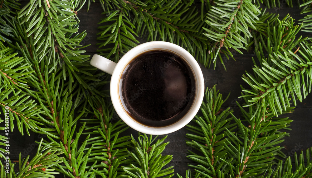 A cup of coffee on fir tree background, top view. A cup of coffee on fir tree background, top view.