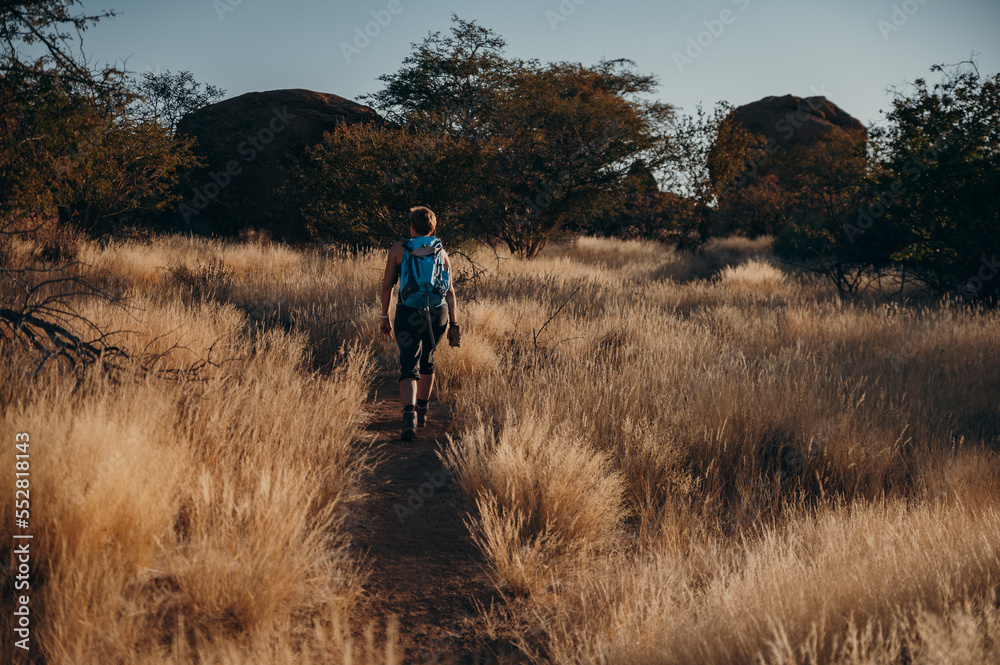 Frau wandert bei Sonnenuntergang durch das Erongo Gebirge, Namibia