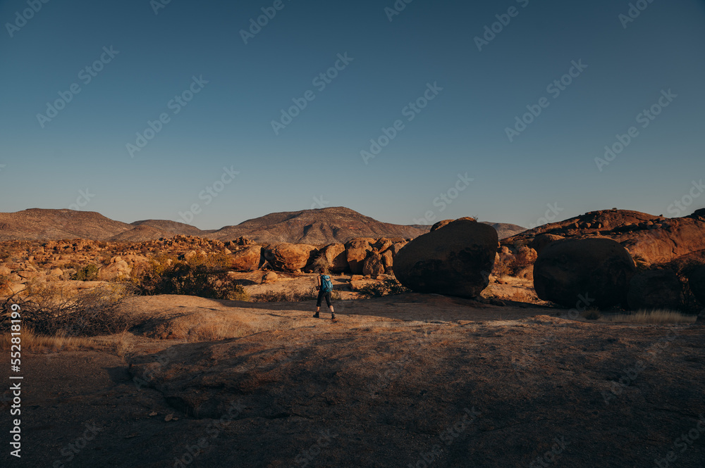 Frau wandert bei Sonnenuntergang durch das Erongo Gebirge, Namibia