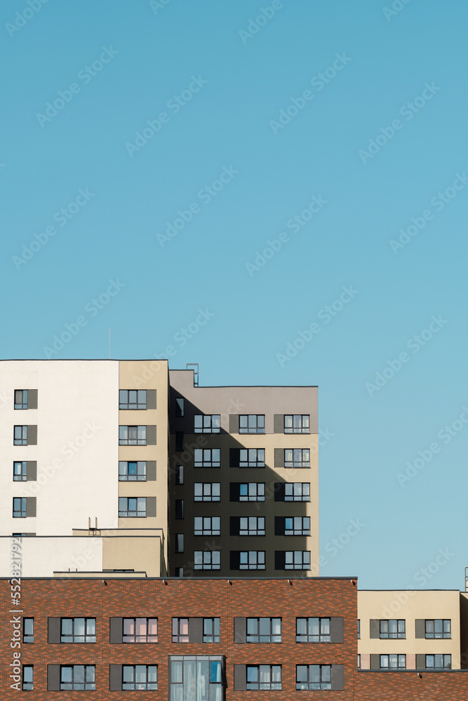 modern Scandinavian building. The bright facade of a multi-apartment building against a blue sky background.