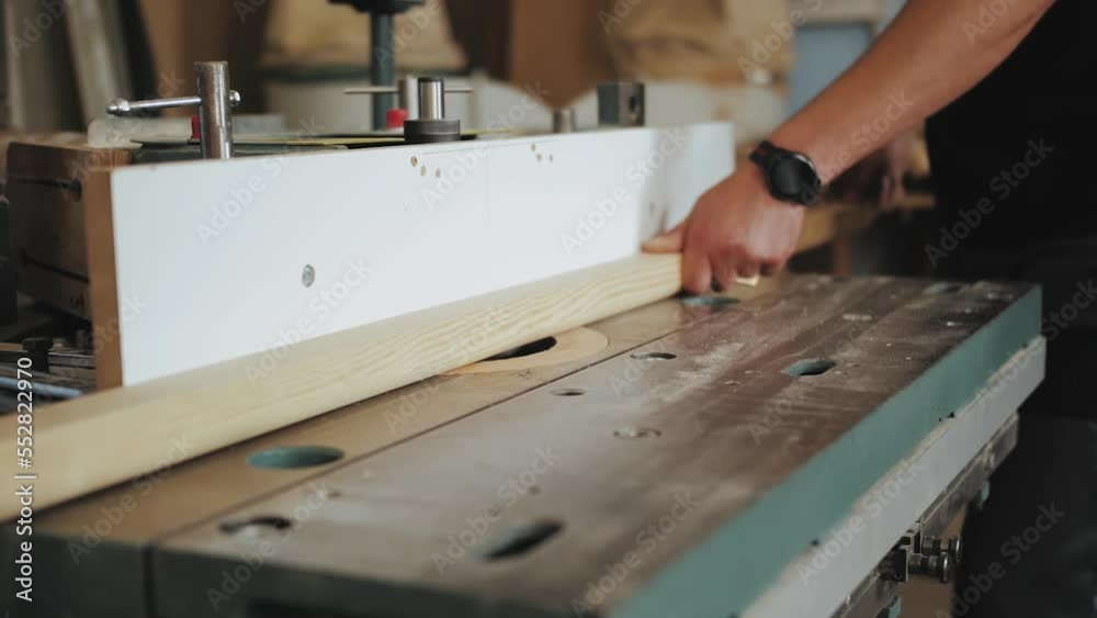 Close-up hands of a factory worker cuts wooden bars on a circular saw. Wooden planks, slow motion shot. Close-up hands of a factory worker cuts wooden bars on a circular saw. Wooden planks, slow motion shot.