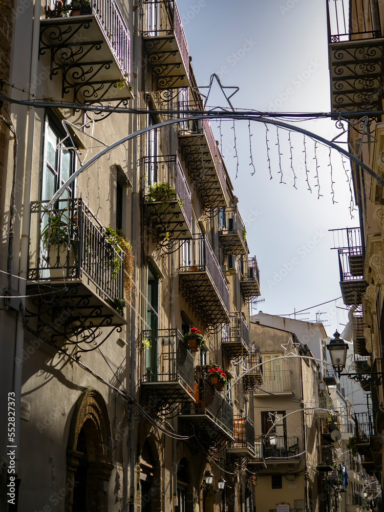 Strada centro storico della città di Cefalù in Sicilia, Italia. Case caratteristiche storiche. Giornata soleggiata a Dicembre
