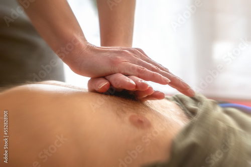 Herzdruckmassage bei einer männlichen Person als Erste-Hilfe-Maßnahme zur Wiederbelebung photo