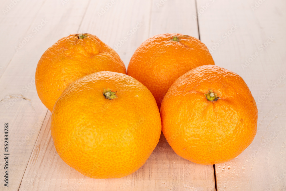 Four ripe tangerines on a wooden table, macro. Four ripe tangerines on a wooden table, macro.