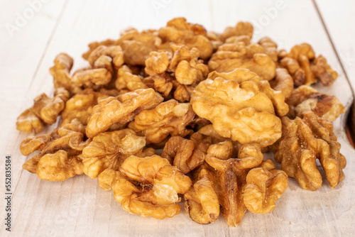 Several peeled walnuts on a wooden table, macro.