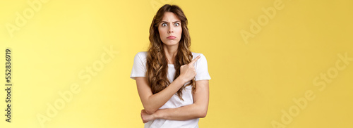 What he doing her. Intense displeased woman see ex-boyfriend behind back standing uncomfortable troublesome situation stare camera angry annoyed pointing upper left corner awkward moment photo