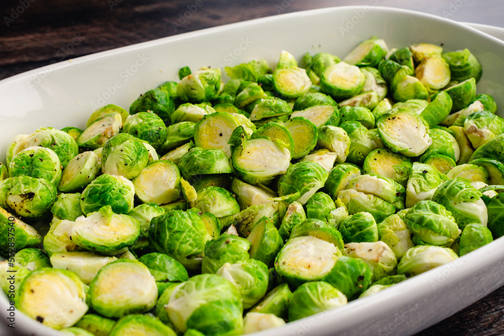 Low Angle View of Halved Brussels Sprouts Tossed in Extra Virgin Olive Oil: A baking dish full of raw Brussels sprouts cut in half and tossed in olive oil, salt and pepper Low Angle View of Halved Brussels Sprouts Tossed in Extra Virgin Olive Oil: A baking dish full of raw Brussels sprouts cut in half and tossed in olive oil, salt and pepper