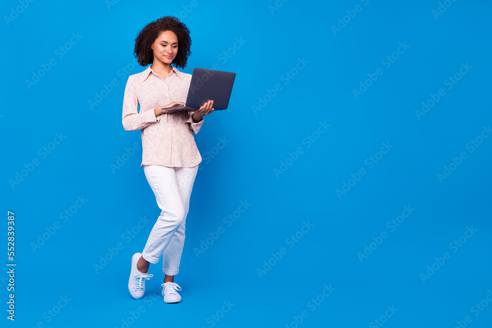 Full size portrait of gorgeous nice lady hold netbook empty space blank isolated on blue color background Full size portrait of gorgeous nice lady hold netbook empty space blank isolated on blue color background