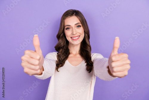 Photo of smiling good mood brunette wavy hairdo girl wear white jumper showing thumbs up likes look you camera isolated on purple color background © deagreez
