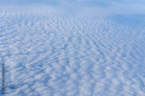 Background of a pink white heavenly sky with fluffy dense clouds  top view from an airplane. Sky Gradient
