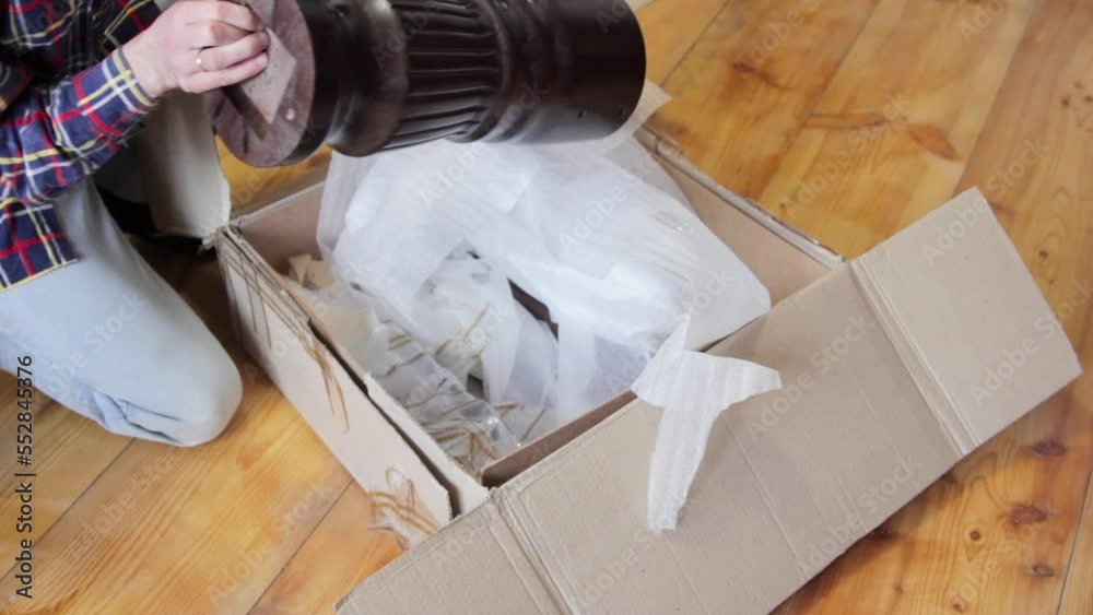unpacking table legs,a man takes round wooden legs from a cardboard box ...