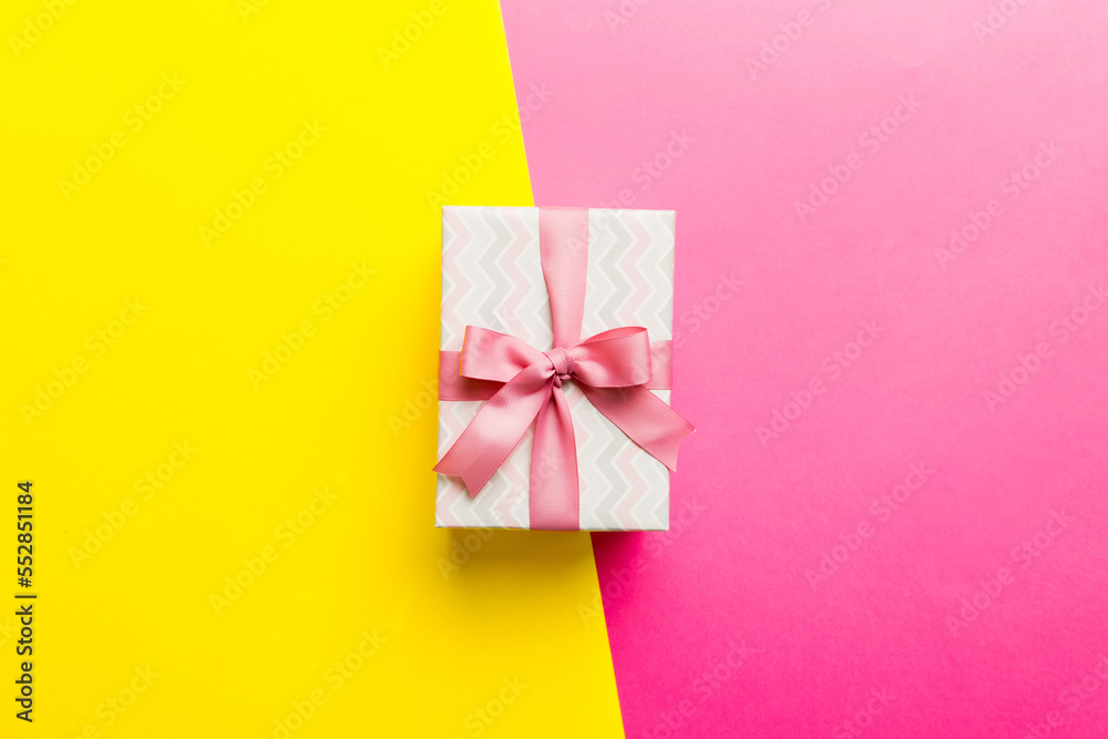holiday paper present tied pink ribbon bow top view with copy space. Flat lay holiday background. Birthday or christmas present. Christmas gift box concept with copy space
