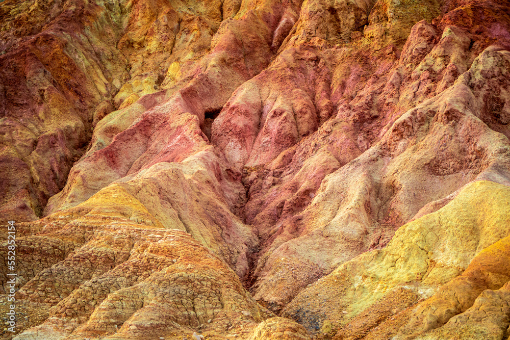 Detailed texture of waste land from a mine with traces of minerals of different colors