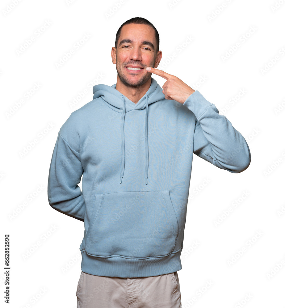 Young man pointing to his teeth