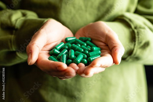 Caffeine capsules on woman's hands. The concept of arousal and energy. photo