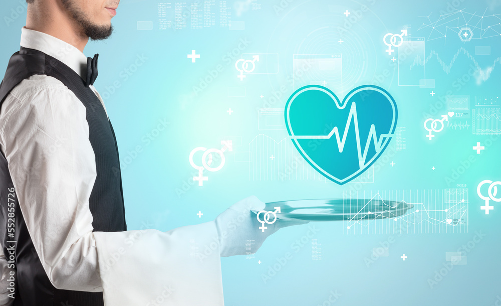 Handsome young waiter in tuxedo holding healthcare icons on tray Handsome young waiter in tuxedo holding healthcare icons on tray
