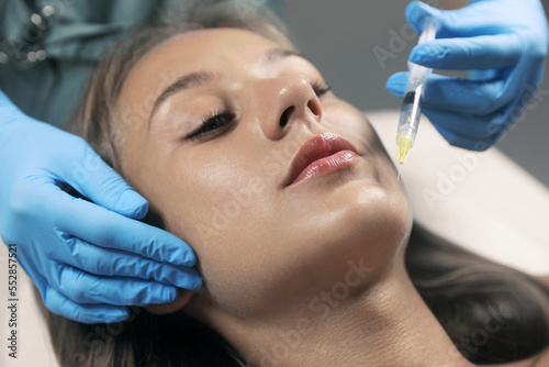 Beautiful woman getting facial injection in salon  closeup