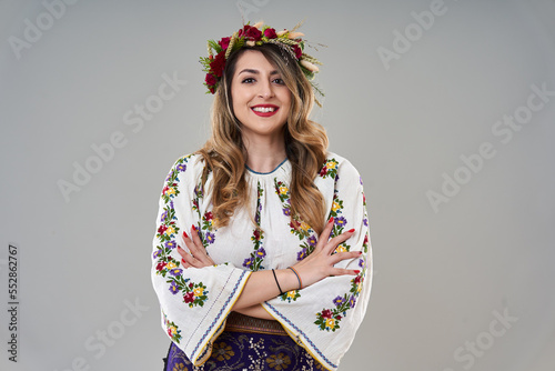 Woman in Romanian traditional costume on gray