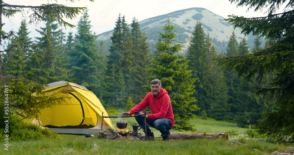 Fototapeta premium Bearded man near a fire in the mountains