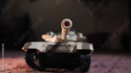 Close-up shot of an isolated radio-controlled toy tank that drives, rotates the turret and fires from the muzzle. Military children's toys. A game of war games with heavy weapons. RC toy tank