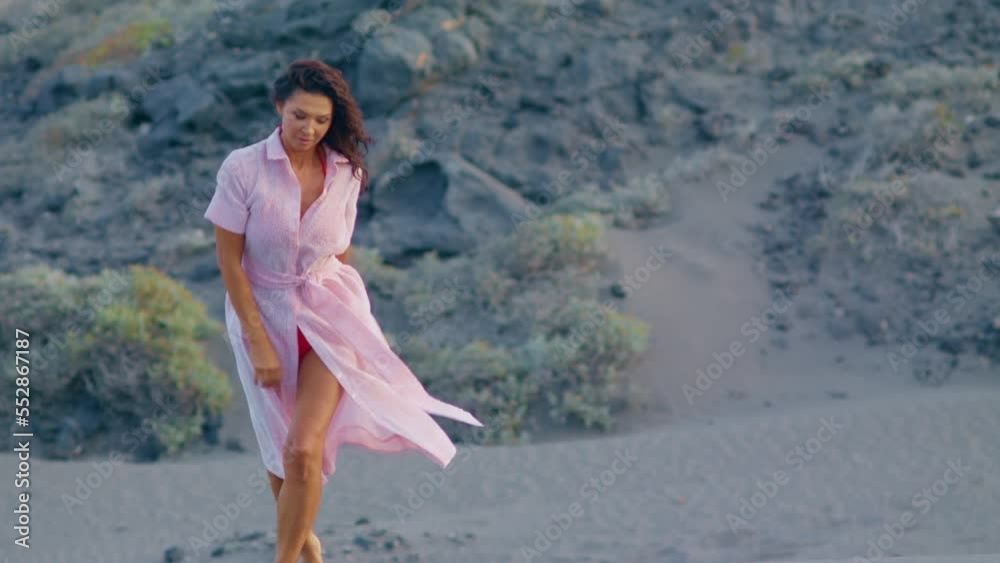 A woman walks barefoot on the sand in the dunes. Beautiful lady with short hair in a pink dress goes slowly through the amazing field full of sand in front of the camera.
Two shots in one. A woman walks barefoot on the sand in the dunes. Beautiful lady with short hair in a pink dress goes slowly through the amazing field full of sand in front of the camera.
Two shots in one.