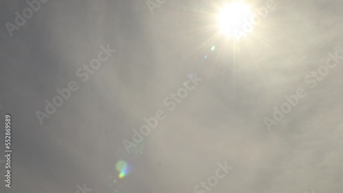 Flat altostratus clouds tinted orange 4K timelapse with sun shining through