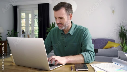 Man working at home using laptop in living room