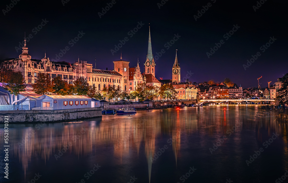 Evening panoramic view of historic Zurich city center with famous Fraumunster and river Limmat at Lake Zurich. Cityscape image of Zurich with reflection. Switzerland