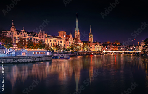 Evening panoramic view of historic Zurich city center with famous Fraumunster and river Limmat at Lake Zurich. Cityscape image of Zurich with reflection. Switzerland © jenyateua