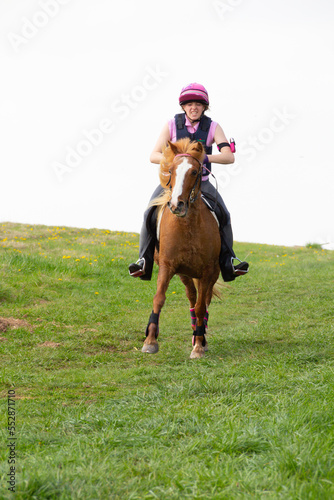 Pretty young girl and her chestnut pony enjoying the freedom of the English countryside, as they. Ride over Shropshire hillside.
